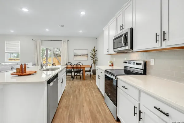 a kitchen with stainless steel appliances kitchen island granite countertop a sink a stove and cabinets