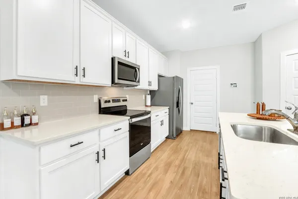 a kitchen with cabinets stainless steel appliances a sink and a counter space