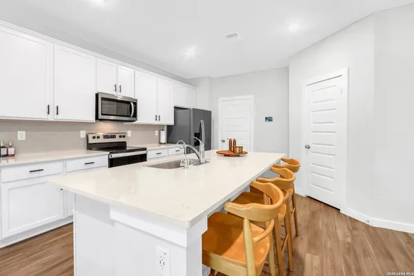 a kitchen with a sink a microwave a stove and cabinets