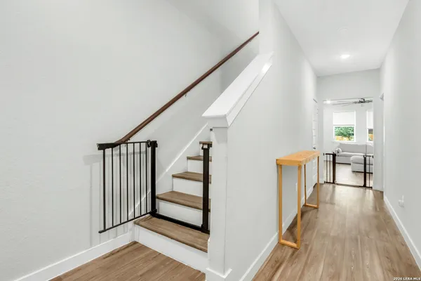 a view of a hallway with wooden floor and stairs
