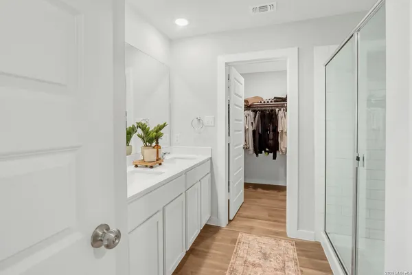 a hallway with white cabinets and wooden floor