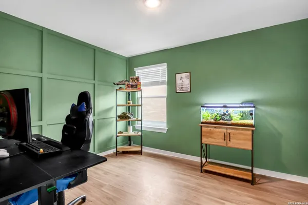 a room with lots of wooden furniture and a fan