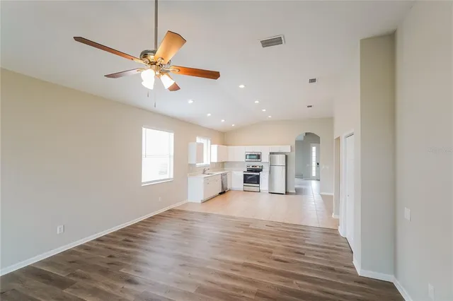 a view of a living room with wooden floor and chandelier