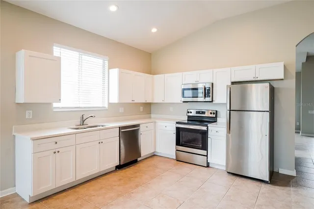 a kitchen with a sink stainless steel appliances and window