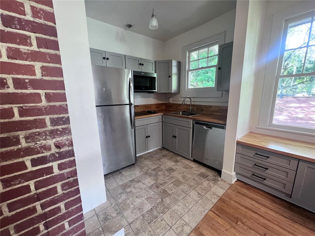 204 Northwest 3 Street Gainesville, FL 32601 - Photo 2 of 5 a kitchen with stainless steel appliances granite countertop a refrigerator and a sink