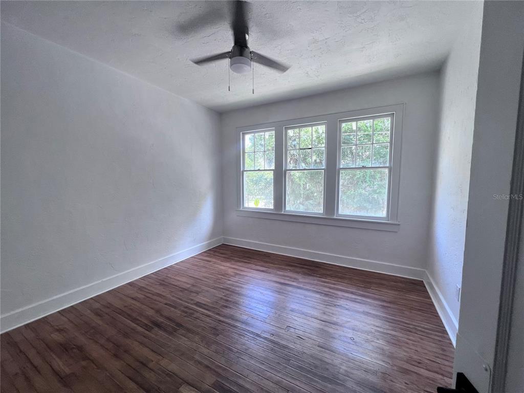 204 Northwest 3 Street Gainesville, FL 32601 - Photo 3 of 5 a view of an empty room with wooden floor and a window