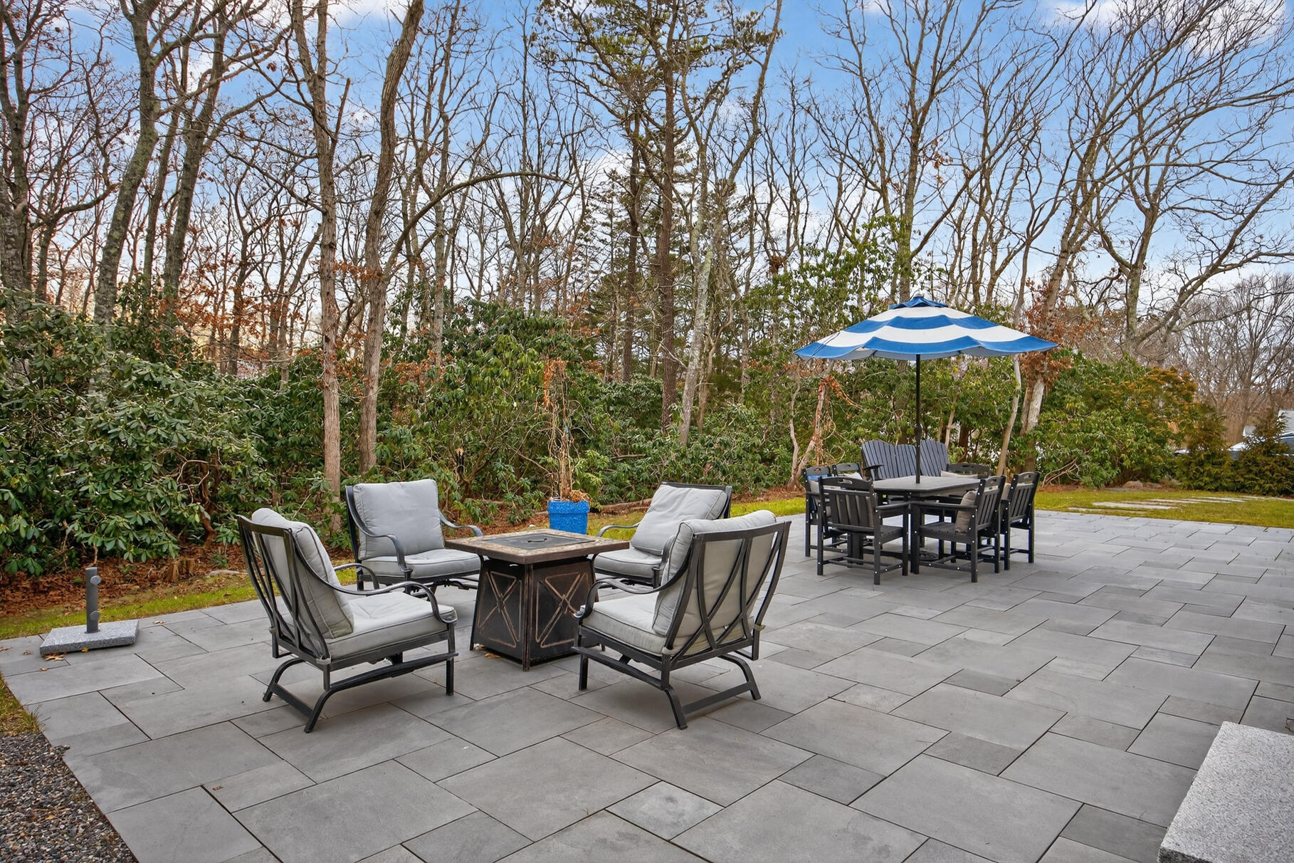 24 Surrey Lane Sandwich, MA 02563 - Photo 52 of 61 a view of a patio with a table and chairs under an umbrella