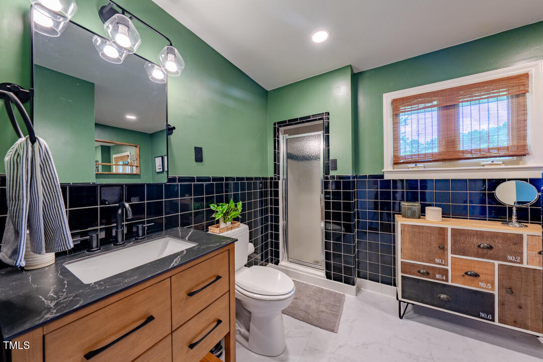 4621 Erwin Road Durham, NC 27705 - Photo 19 of 40 a bathroom with a sink a toilet and shower