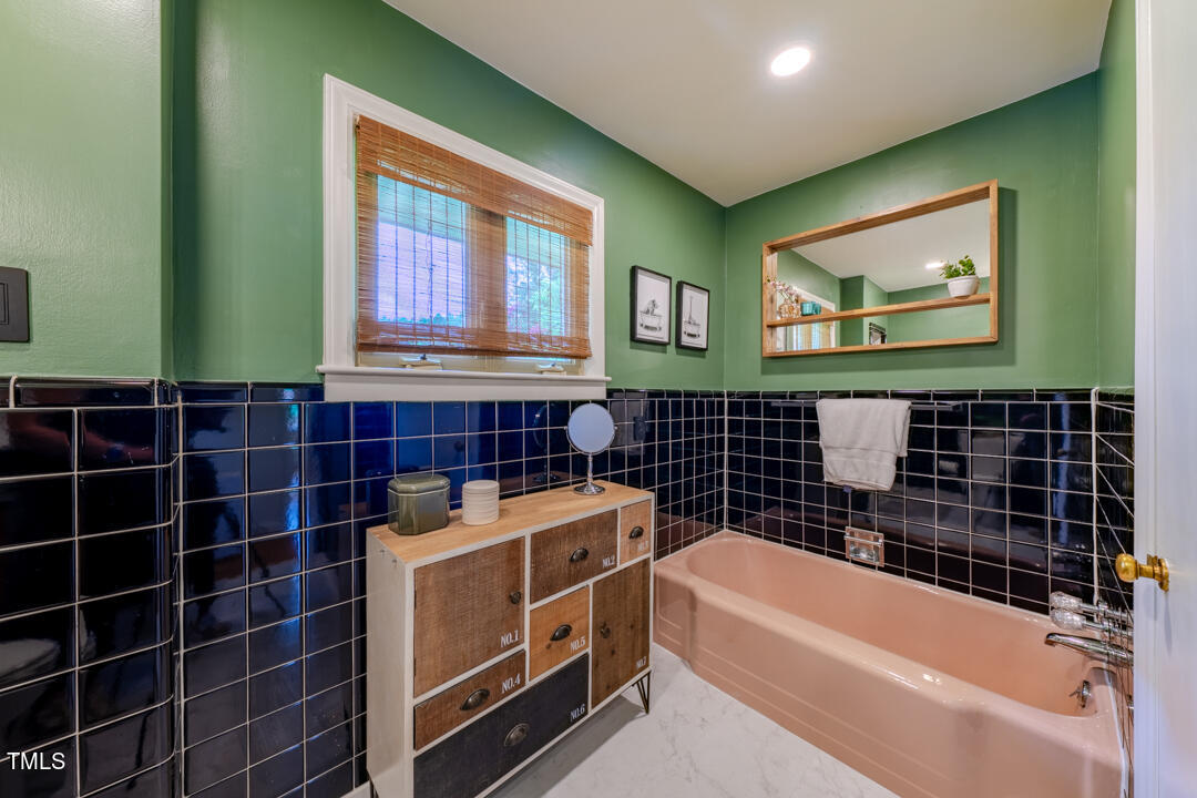 4621 Erwin Road Durham, NC 27705 - Photo 20 of 40 a bathroom with a bathtub sink and window