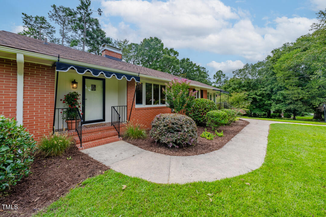 4621 Erwin Road Durham, NC 27705 - Photo 2 of 40 a view of a backyard with potted plants and large tree