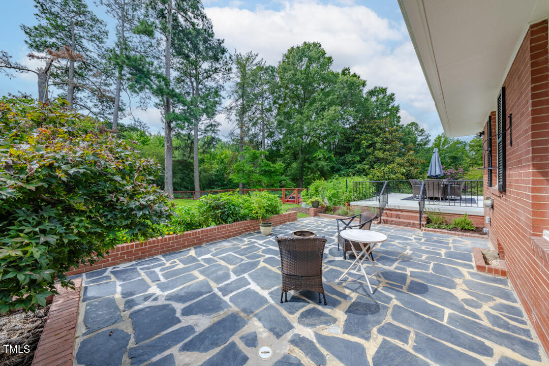 4621 Erwin Road Durham, NC 27705 - Photo 25 of 40 a view of a patio with table and chairs potted plants and large tree