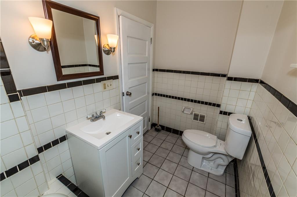 631 Beaver Road Ambridge, PA 15003 - Photo 11 of 25 2nd floor bathroom has new vanity, cabinetry and lighting. The floor and walls are tiled with a ceramic tub.