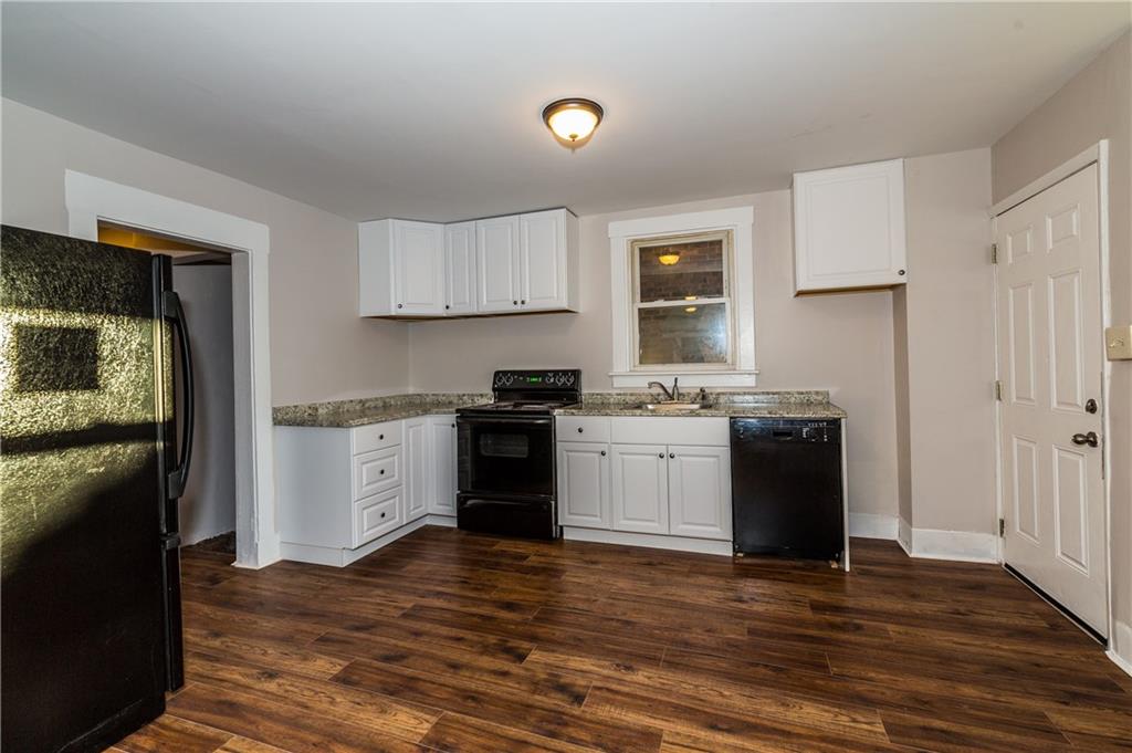 631 Beaver Road Ambridge, PA 15003 - Photo 6 of 25 The kitchen is next to the dining room and host new cabinets and beautiful black appliances. The door to the right of the kitchen leads to the first floor of the deck. The wooden floor accents the room and brings back warm holiday memories.