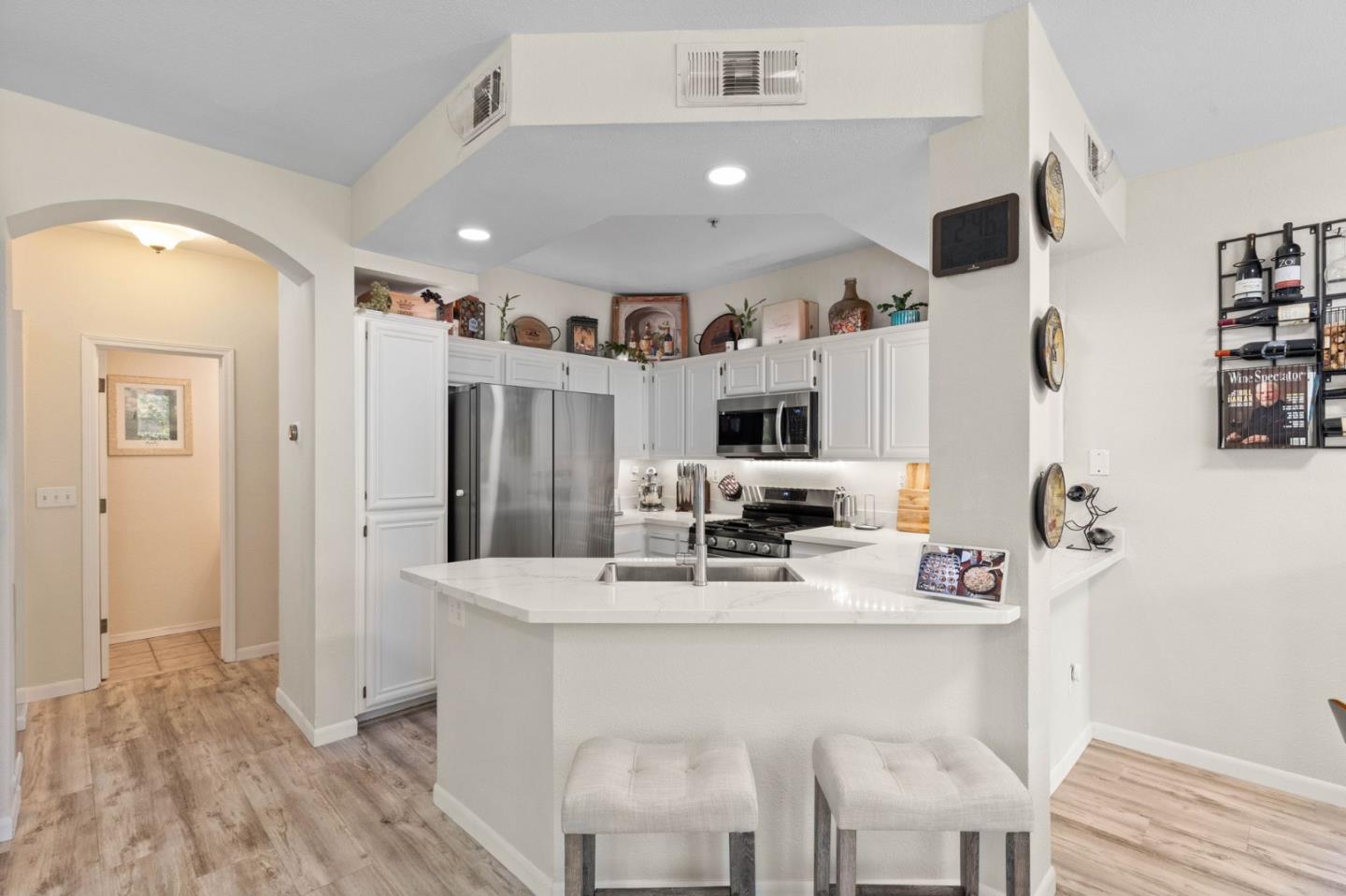 3337 Midtown Place San Jose, CA 95136 - Photo 9 of 32 a kitchen with stainless steel appliances kitchen island granite countertop a refrigerator a stove a sink dishwasher and white cabinets with wooden floor