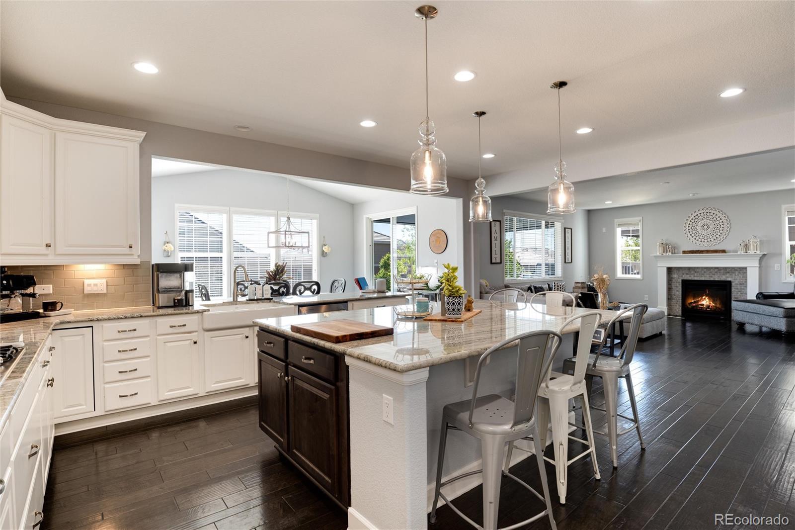 14390 Double Dutch Loop Parker, CO 80134 - Photo 13 of 50 a kitchen with stainless steel appliances granite countertop a stove top oven a sink dishwasher a dining table and chairs with wooden floor