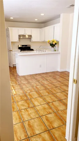 a kitchen with stainless steel appliances a stove a sink and a refrigerator