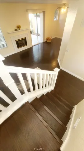 an empty room with wooden floor and windows with curtains