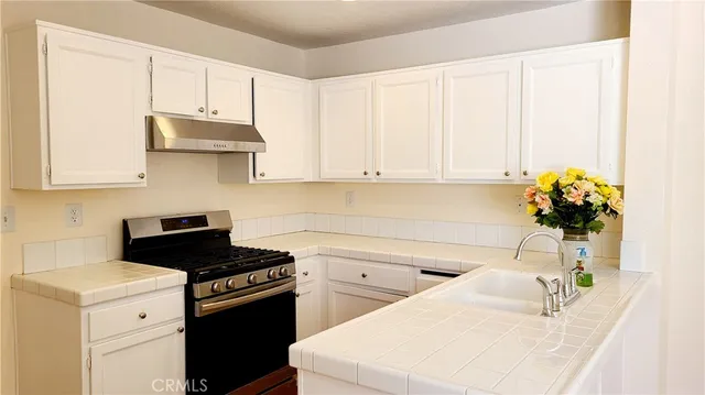 a kitchen with stainless steel appliances white cabinets and a stove