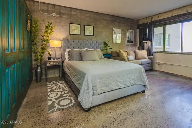 a spacious bedroom with a bed and a large window