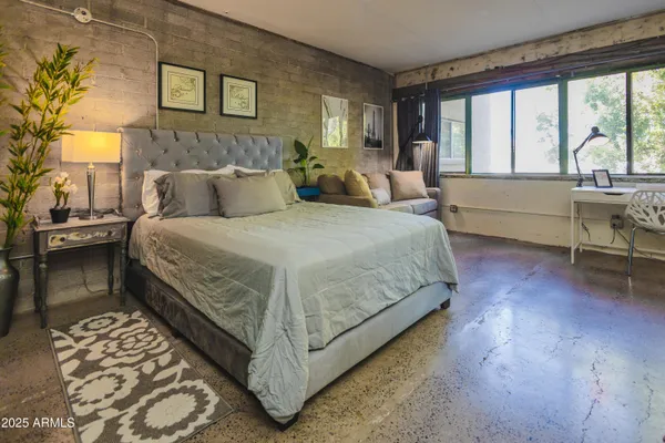 a bedroom with a bed and a lamp next to a window