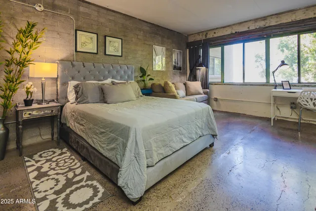 a bedroom with a bed and a lamp next to a window