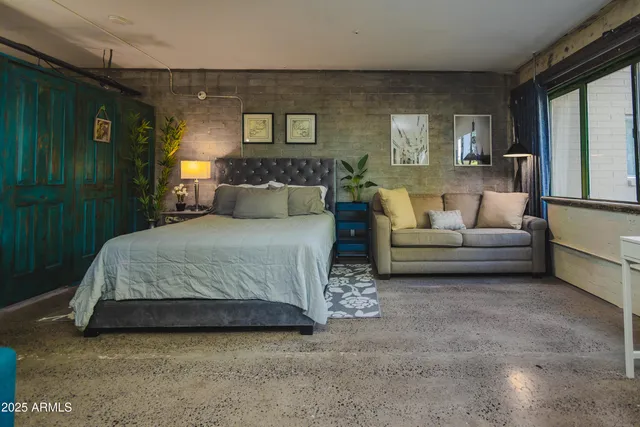 a spacious bedroom with a bed couch and a window