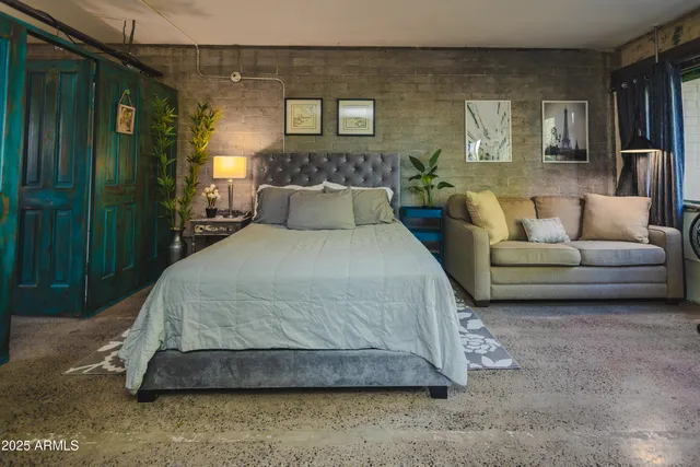 a living room with a bed and a night stand