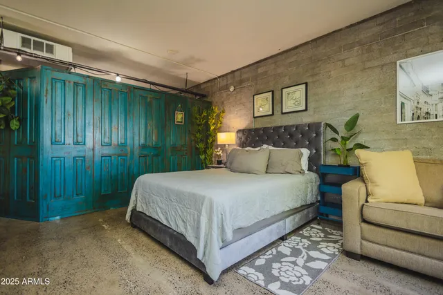 a bed sitting in a bedroom next to a bathroom