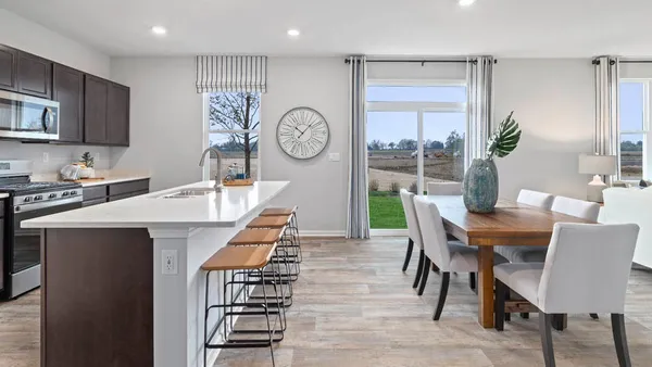 a dining room with wooden floor a table and chairs