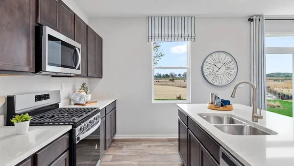 a kitchen with stainless steel appliances granite countertop a stove a sink and a microwave