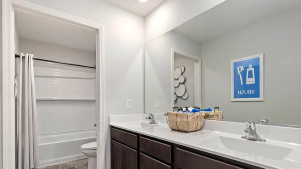 a bathroom with a granite countertop sink a toilet and a mirror