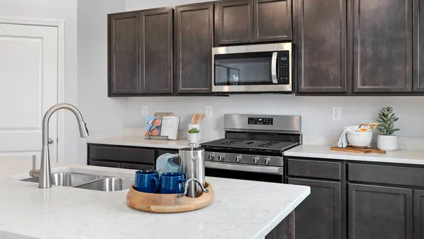 a kitchen with a stove and a microwave with wooden floor