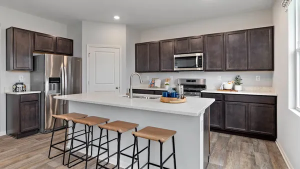 a kitchen with stainless steel appliances wooden cabinets a stove a sink and a refrigerator