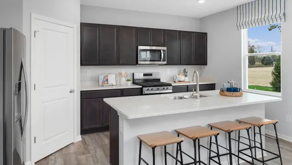 a kitchen with stainless steel appliances a microwave a sink and cabinets