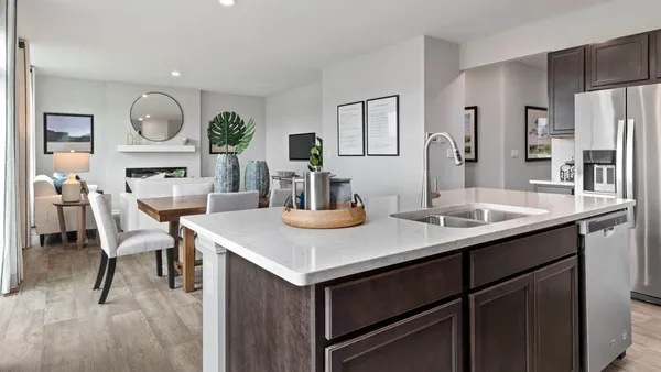 a view of kitchen island with stainless steel appliances kitchen island a table chairs and a refrigerator