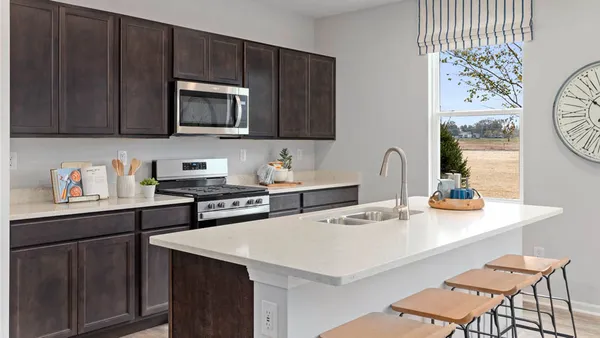 a kitchen with stainless steel appliances a sink a stove a microwave a sink and cabinets