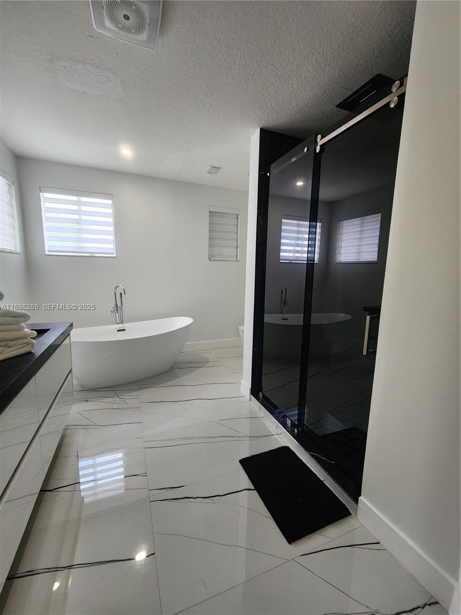 16411 Southwest 60th Terrace Miami, FL 33193 - Photo 14 of 37 a spacious bathroom with a bathtub and a shower