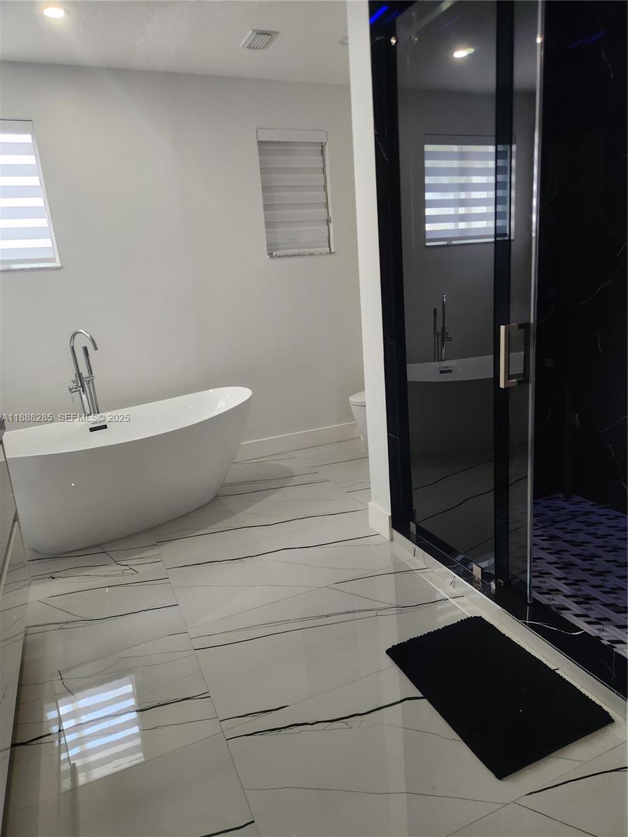 16411 Southwest 60th Terrace Miami, FL 33193 - Photo 17 of 37 a bathroom with a bathtub and shower
