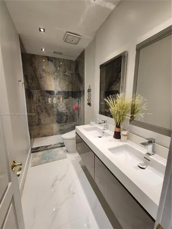 a bathroom with a sink a large mirror and a shower