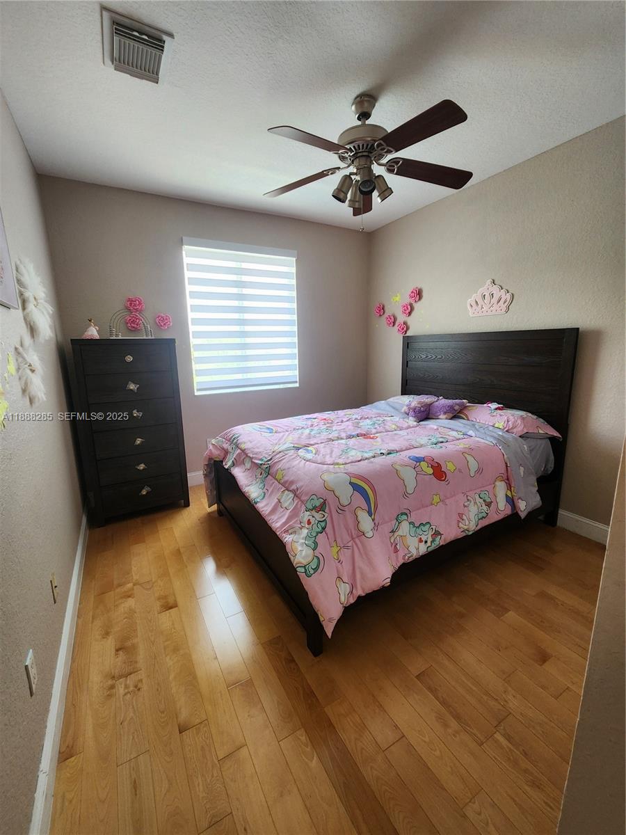 16411 Southwest 60th Terrace Miami, FL 33193 - Photo 22 of 37 a bedroom with a bed and a ceiling fan