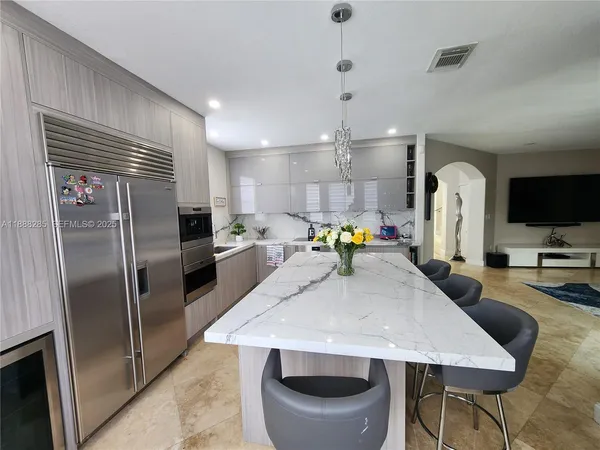a kitchen with stainless steel appliances granite countertop a sink refrigerator stove and microwave