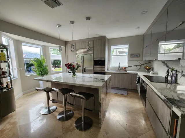 a kitchen with stainless steel appliances granite countertop a sink a stove and a refrigerator