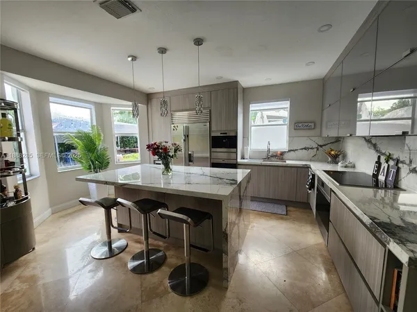 a kitchen with stainless steel appliances granite countertop a sink a stove and a refrigerator