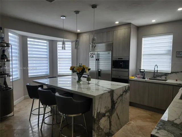 a kitchen with granite countertop a sink counter space and dining table in it
