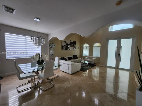 a living room with patio couch and a chandelier