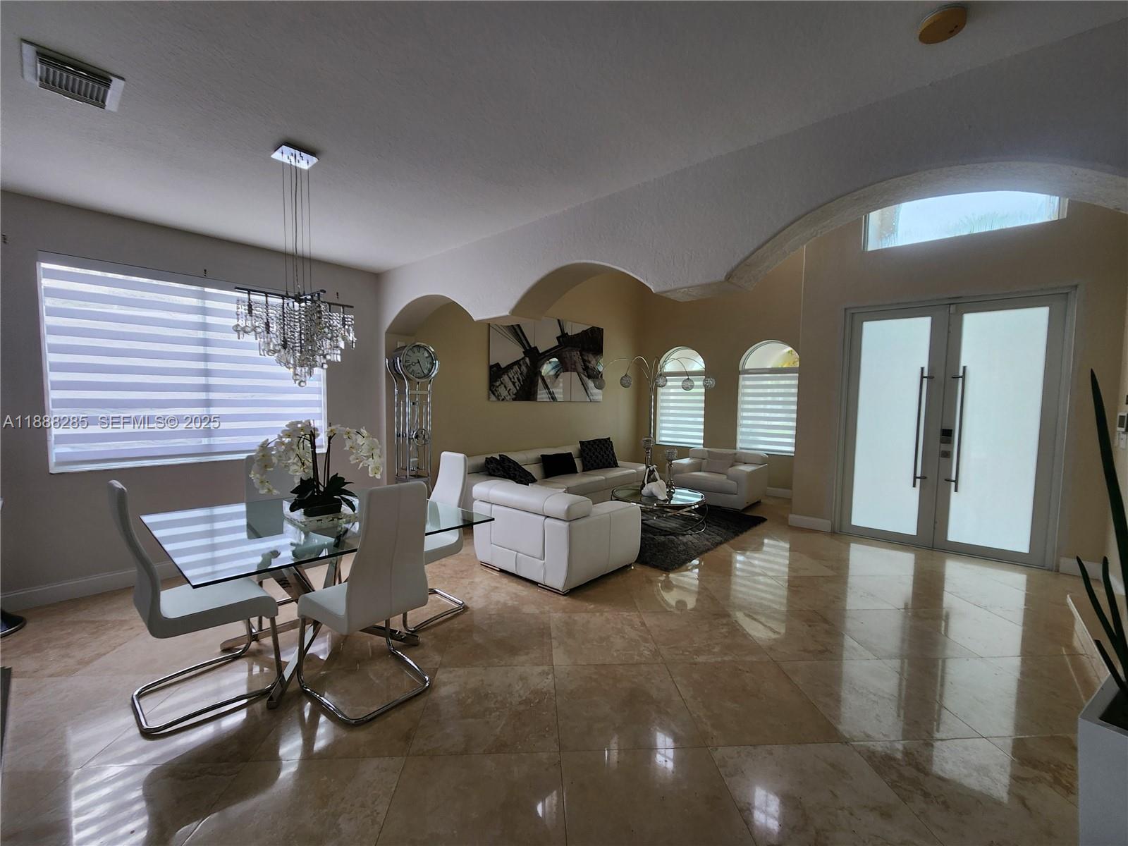 16411 Southwest 60th Terrace Miami, FL 33193 - Photo 8 of 37 a living room with patio couch and a chandelier