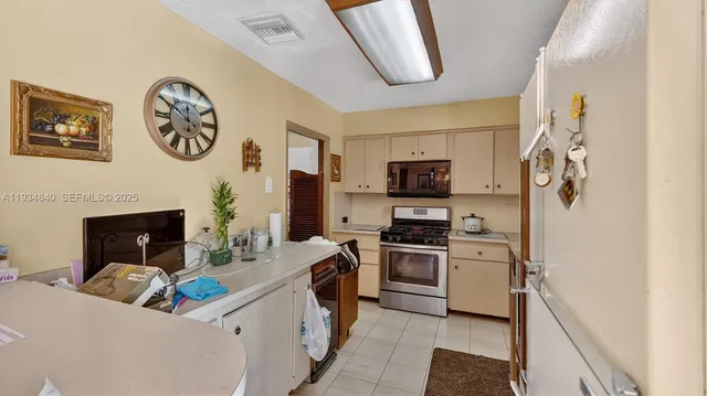 a very nice looking open kitchen with stainless steel appliances granite countertop a stove and a sink