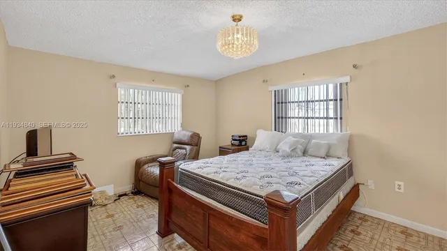 a bedroom with a bed and a tv on the dresser