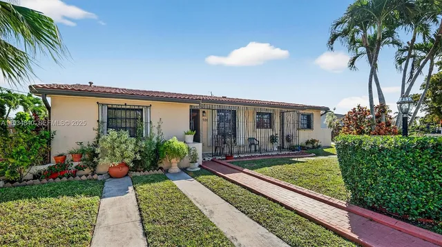a view of a house with backyard and sitting area
