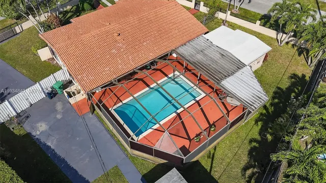 an aerial view of residential houses with outdoor space and trees